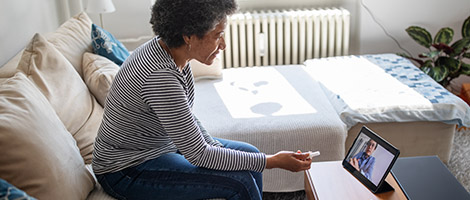 An older woman using her tablet for her video visit with her doctor.