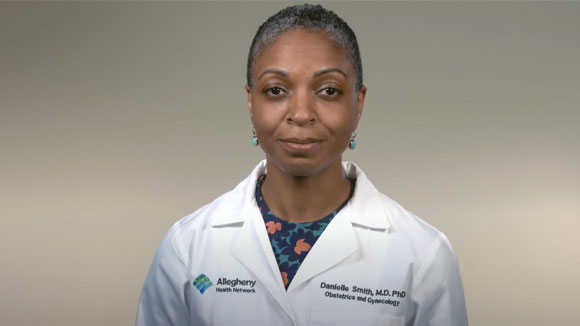 Maternity Dr. Danielle Smith smiling in front of beige background