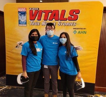 AHN Cardiovascular Disease fellows standing in front of the Marvel graphic novel "The Vitals: True Nurse Stories" by Marvel and AHN.