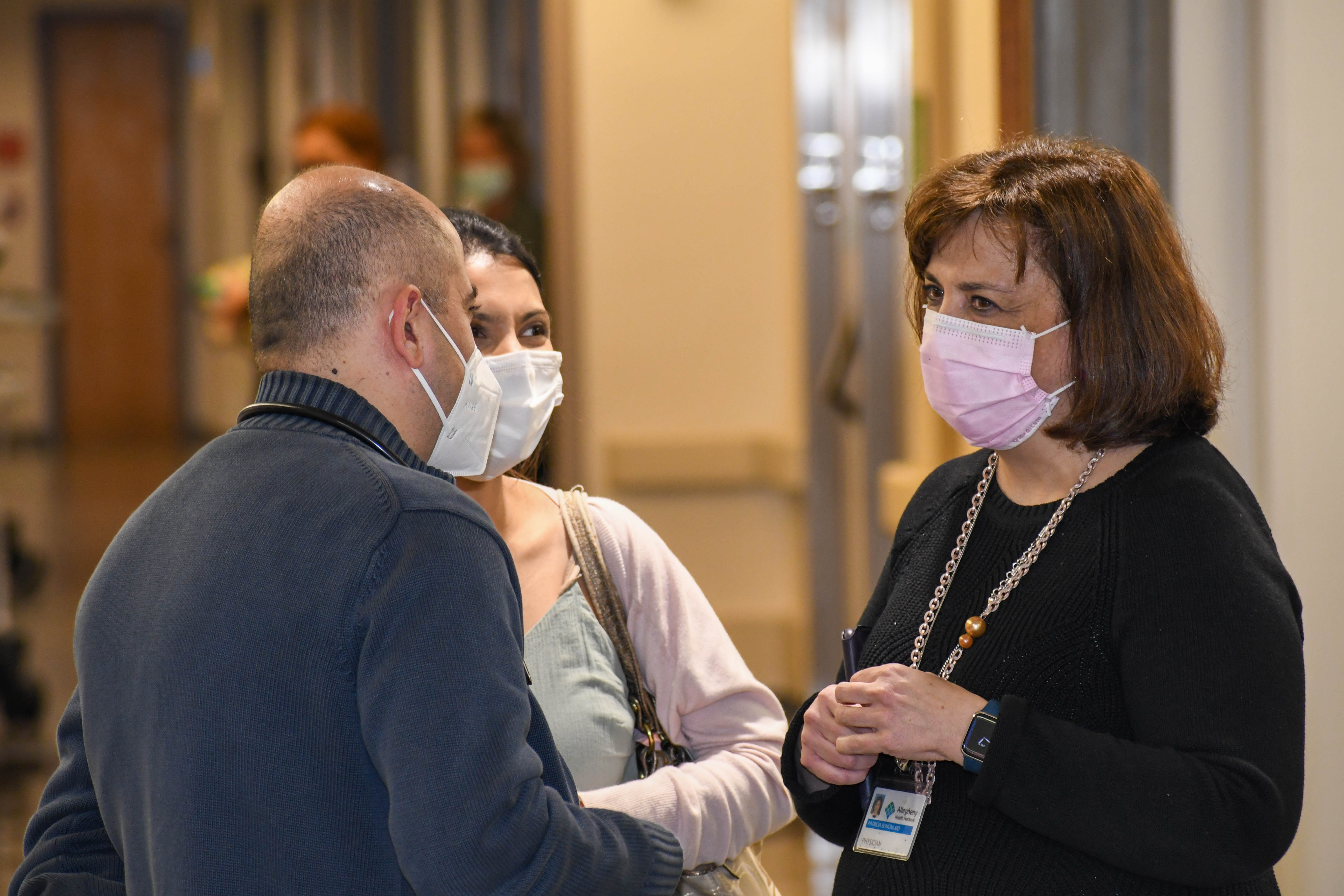 AHN faculty wearing masks talking to each other.