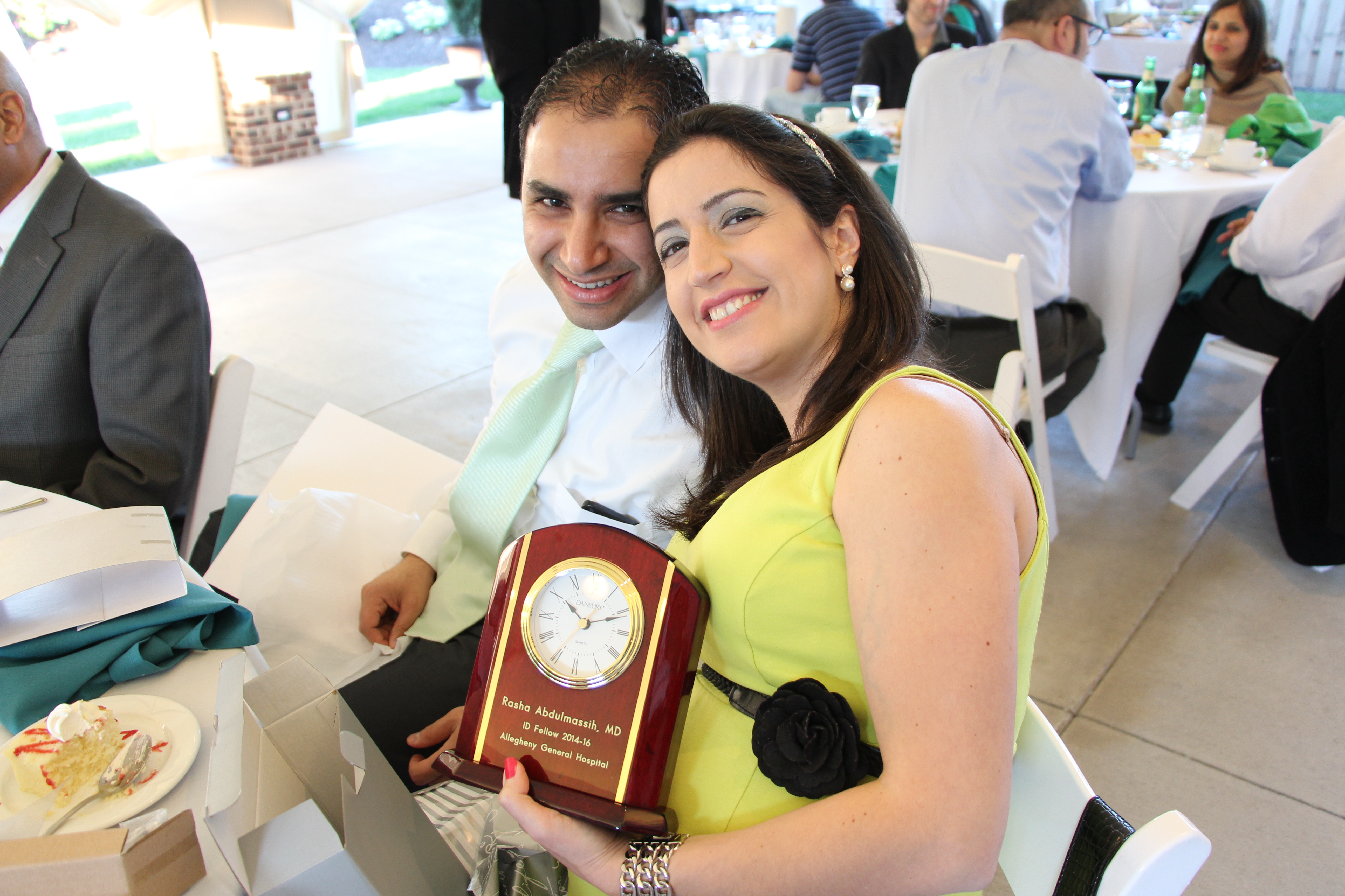 2015-2016 graduate Rasha Abdulmassih, MD holding a graduation gift at a dinner party.