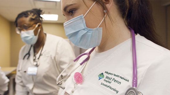 Two masked nursing students in a classroom