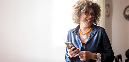 woman smiling while holding phone