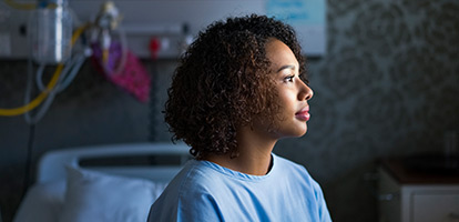 Close-up of a woman in a doctor's office looking towards a window.