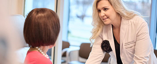 AHN cancer specialist talking to a patient in a chair