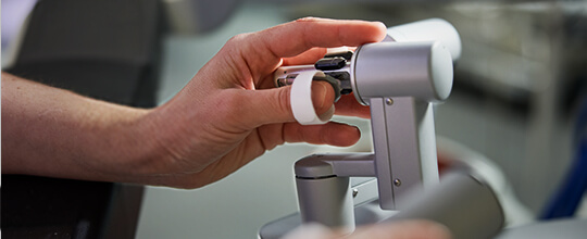 A hand on a piece of medical equipment