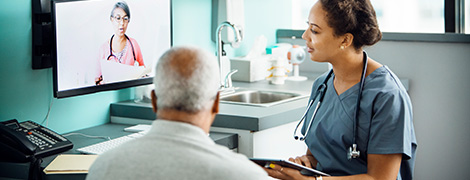 A doctor and patient consulting with another doctor over telemedicine.