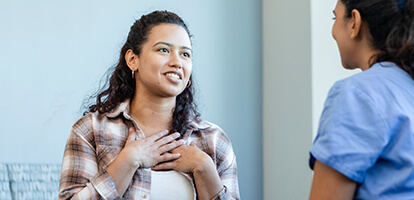Patient with a hopeful expression speaking with a healthcare professional.