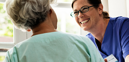 A smiling female doctor reaching out to a patient