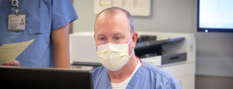 A nurse looking at his computer.