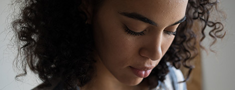 A close-up of a woman's face looking down.