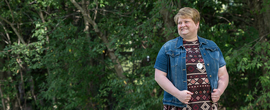 AHN Saint Vincent Hospital patient Grace Kizina standing in front of some trees and looking off camera.